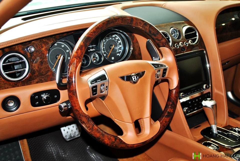 Vô-lăng kết hợp giữa da bò và gỗ ốp quý hiếm. Một số nút bấm được tích hợp trên vô-lăng đều bằng nhôm