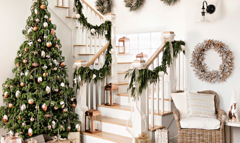 cầu thang được trang tr&iacute; bằng d&acirc;y th&ocirc;ng tươi, b&ecirc;n cạnh l&agrave; c&acirc;y th&ocirc;ng Noel