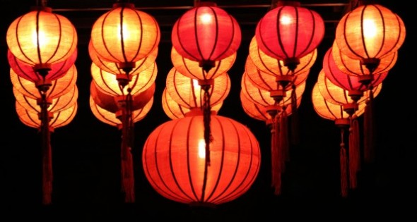 Những chiếc đèn lồng đỏ hình tròn treo thành hàng ngăn nắp trên nền đen.
