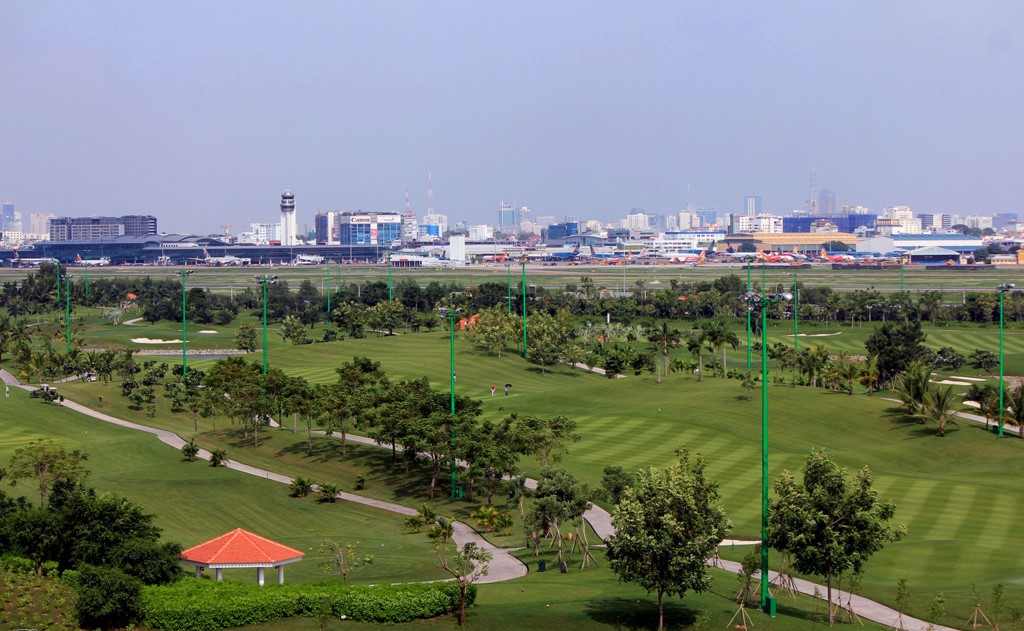 một khu đất trống, phía xa là những tòa nhà cao tầng