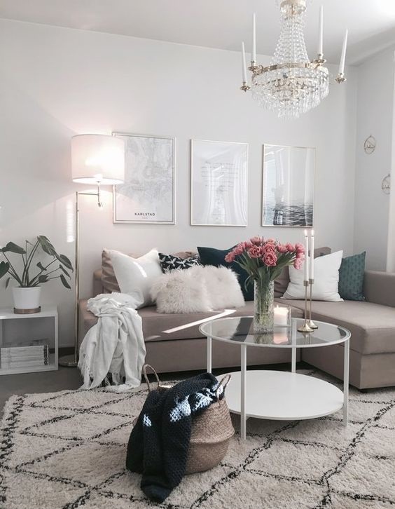 H&igrave;nh ảnh ph&ograve;ng kh&aacute;ch nhỏ với sofa m&agrave;u be, b&agrave;n tr&agrave; tr&ograve;n hai tầng đặt tr&ecirc;n thảm trải họa tiết đen trắng