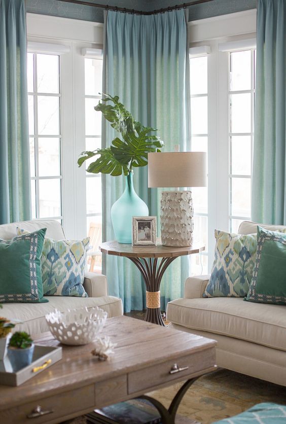 H&igrave;nh ảnh một g&oacute;c ph&ograve;ng kh&aacute;ch với ghế sofa m&agrave;u sữa, r&egrave;m m&agrave;u xanh bạc h&agrave; thanh lịch