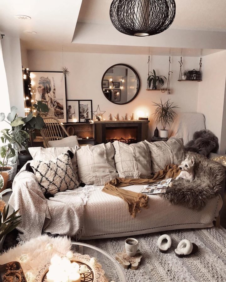 H&igrave;nh ảnh một g&oacute;c ph&ograve;ng kh&aacute;ch m&agrave;u be với sofa ghi lướn, chăn trải mềm mại, trang tr&iacute; bằng khung gương tr&ograve;n, đ&egrave;n ch&ugrave;m độc đ&aacute;o