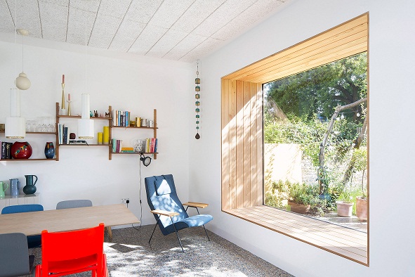 H&igrave;nh ảnh ph&ograve;ng l&agrave;m việc với ghế nhiều m&agrave;u sắc, kệ mở gắn tường, cửa sổ k&iacute;nh lớn mở ra s&acirc;n sau nh&agrave; xanh m&aacute;t.