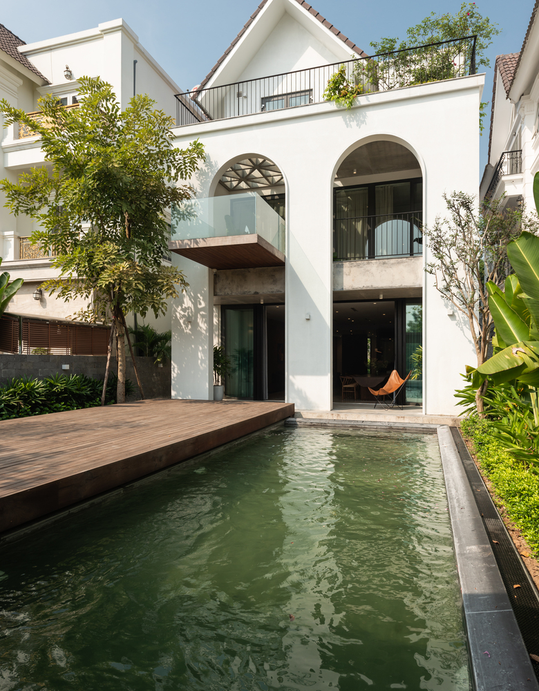 Toàn cảnh biệt thự mang hơi hướng tân cổ điển Hình ảnh toàn cảnh biệt thự màu trắng, khung vòm cao rộng, hồ nước phía trước