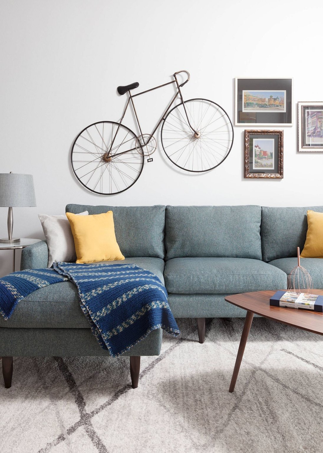 H&igrave;nh ảnh cận cảnh ph&ograve;ng kh&aacute;ch nhỏ với ghế sofa m&agrave;u xanh dương, gối tựa m&agrave;u v&agrave;ng nổi bật, thảm trải x&aacute;m