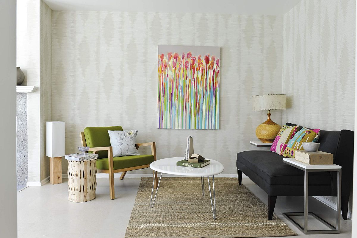 H&igrave;nh ảnh ph&ograve;ng kh&aacute;ch nhỏ m&agrave;u trắng với sofa đen, ghế b&agrave;nh xanh l&aacute;, tranh treo tường nghệ thuật