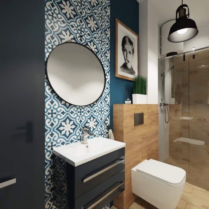 H&igrave;nh ảnh một g&oacute;c ph&ograve;ng tắm được trang tr&iacute; với mảng tường xanh dương, gạch ốp c&ugrave;ng t&ocirc;ng v&agrave; gương tr&ograve;n lớn