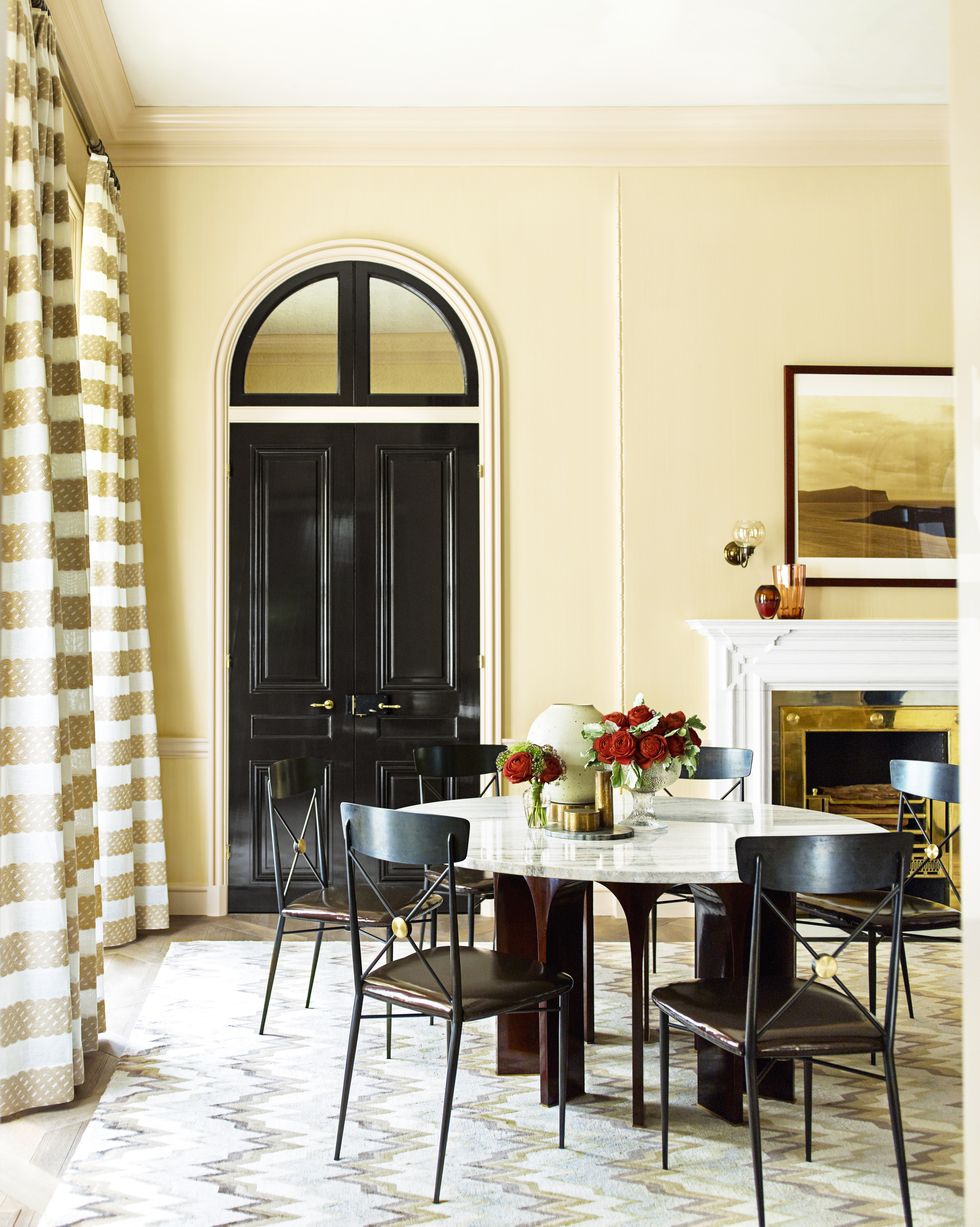 H&igrave;nh ảnh ph&ograve;ng ăn với t&ocirc;ng m&agrave;u v&agrave;ng nhạt ấm &aacute;p, b&agrave;n tr&ograve;n trung t&acirc;m, cửa sổ v&ograve;m cổ điển