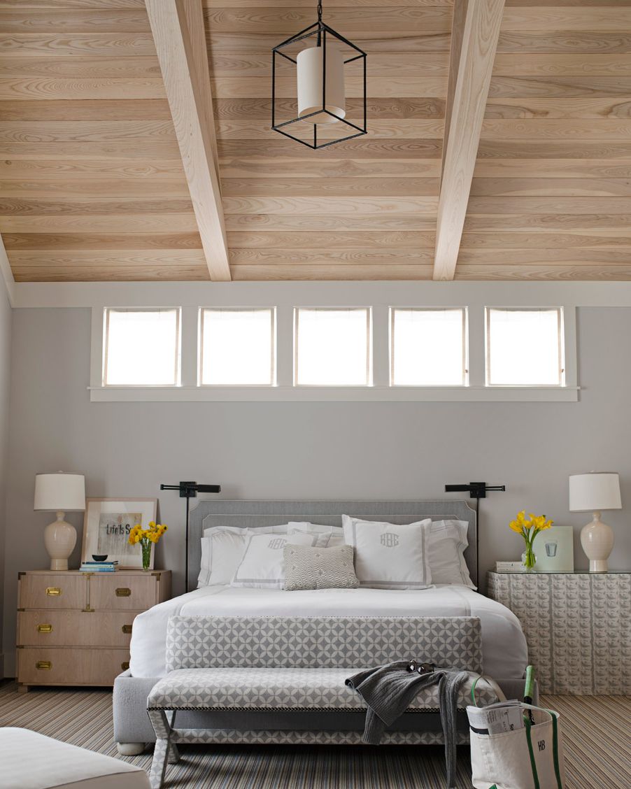 H&igrave;nh ảnh ph&ograve;ng ngủ m&agrave;u x&aacute;m nhạt với trần ốp gỗ, nhiều &ocirc; cửa sổ k&iacute;nh đầu giường, đ&egrave;n trang tr&iacute;, hai b&ecirc;n giường l&agrave; tủ đựng đồ