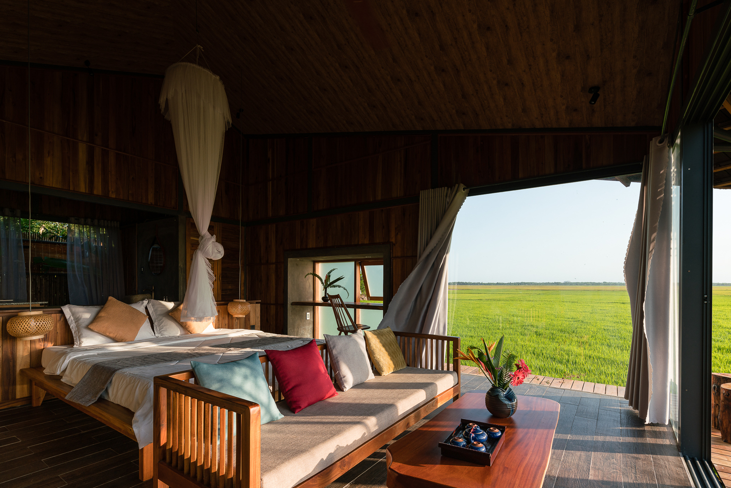 Hình ảnh bên trong nhà nghỉ dưỡng với phòng ngủ tối giản, thoáng sáng, view đồng lúa