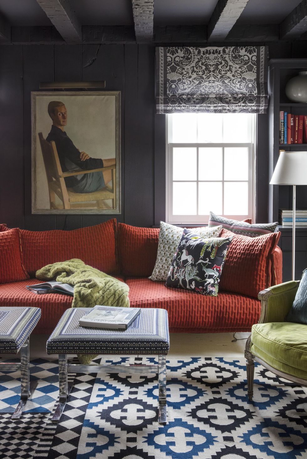 Hình ảnh phòng khách nhỏ với tường và trần sơn màu xanh than, điểm nhấn ấn tượng là sofa đỏ