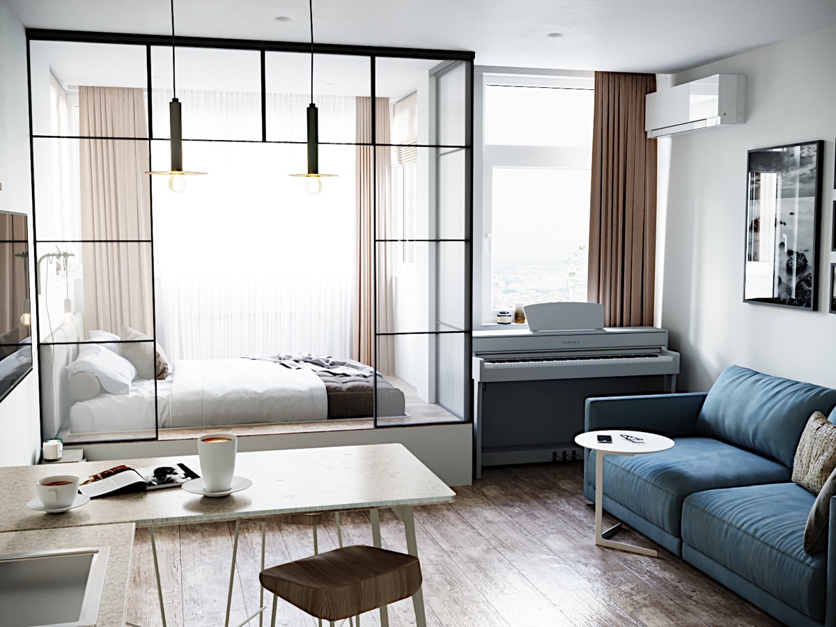 H&igrave;nh ảnh b&ecirc;n trong căn h&ocirc; studio với sofa xanh dương, cạnh đ&oacute; l&agrave; b&agrave;n ăn, g&oacute;c đặt đ&agrave;n piano, ph&ograve;ng ngủ sau v&aacute;ch k&iacute;nh trong suốt