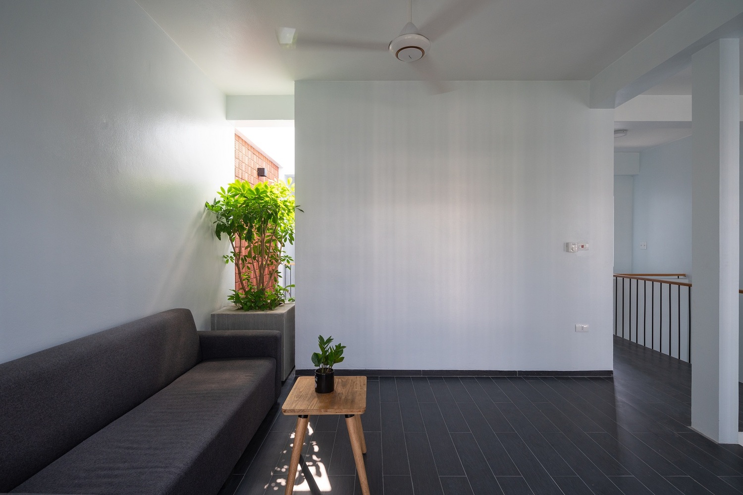 Hình ảnh phòng sinh hoạt chung với bàn trà gỗ, sofa màu xám đen