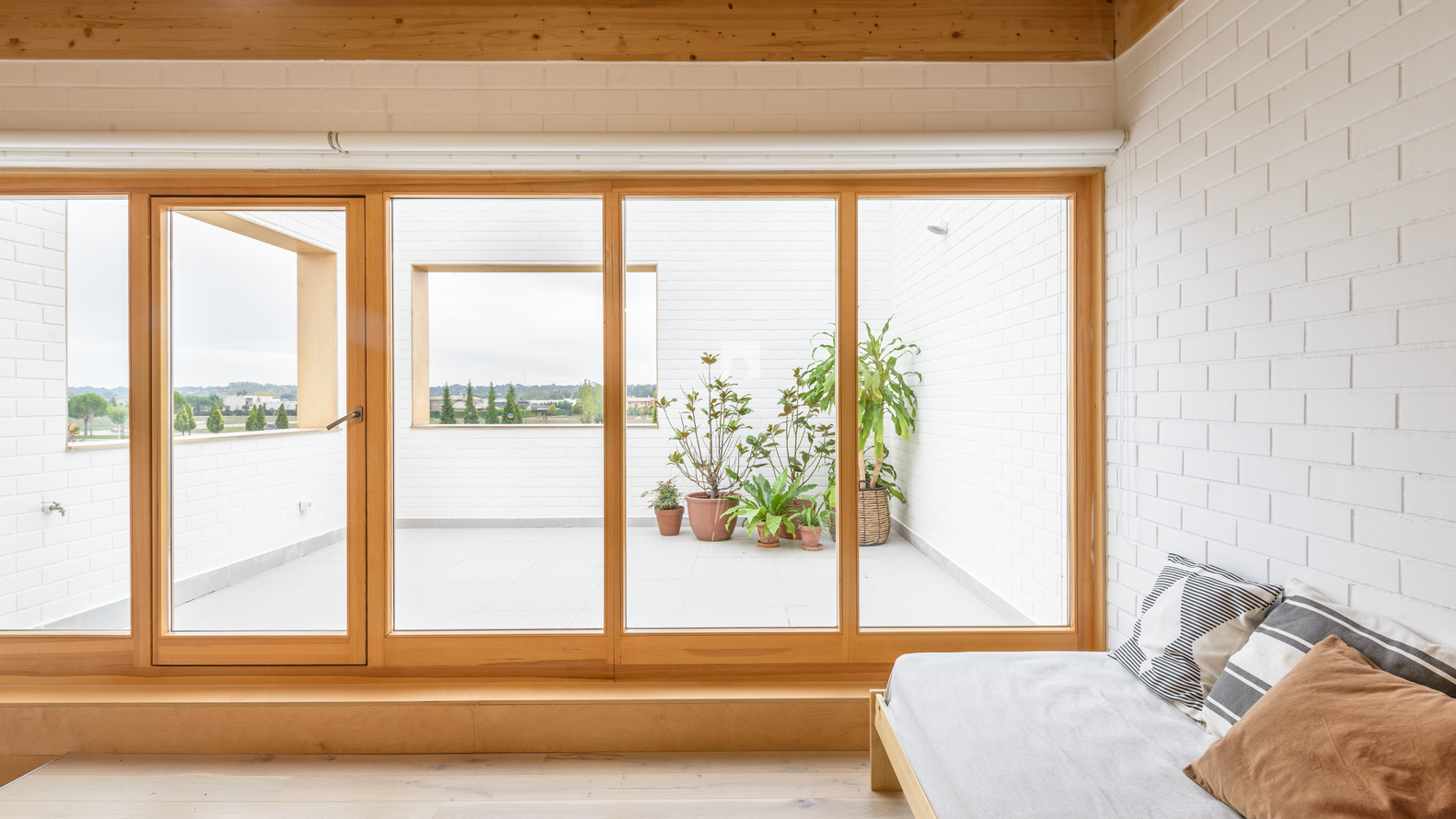 H&igrave;nh ảnh một g&oacute;c ph&ograve;ng ngủ c&oacute; cửa k&iacute;nh mở ra s&acirc;n thượng