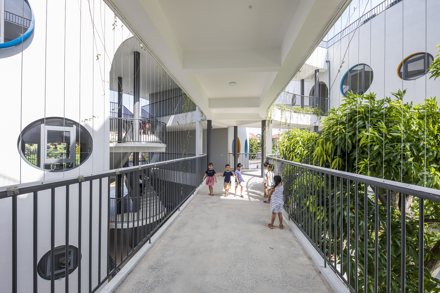 H&igrave;nh ảnh cận cảnh c&aacute;c b&eacute; đang đi lại tr&ecirc;n c&acirc;y cầu kết nối hai t&ograve;a nh&agrave; trường mẫu gi&aacute;o