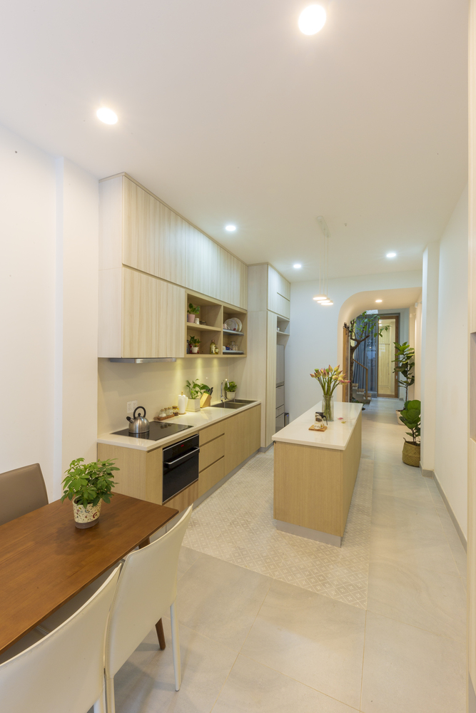H&igrave;nh ảnh ph&ograve;ng bếp đơn giản, tiện nghi trong nh&agrave; Vy Anh với hệ tủ gỗ m&agrave;u s&aacute;ng, đảo bếp trung t&acirc;m, b&agrave;n ăn ngay cạnh