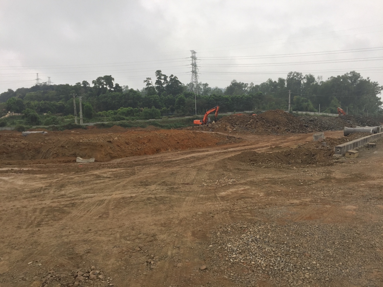 Một dự &aacute;n đất nền tỉnh lẻ đang san lấp mặt bằng, m&aacute;y x&uacute;c đất đang l&agrave;m việc.