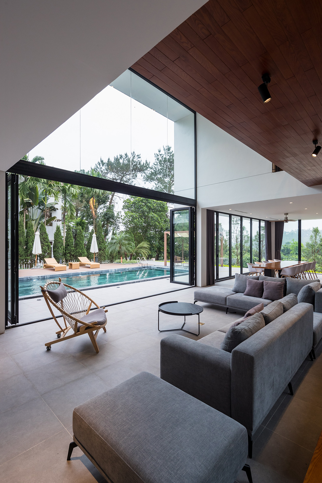 h&igrave;nh ảnh ph&ograve;ng kh&aacute;ch hiện đại, ngập tr&agrave;n &aacute;nh s&aacute;ng với sofa x&aacute;m, s&agrave;n b&ecirc; t&ocirc;ng