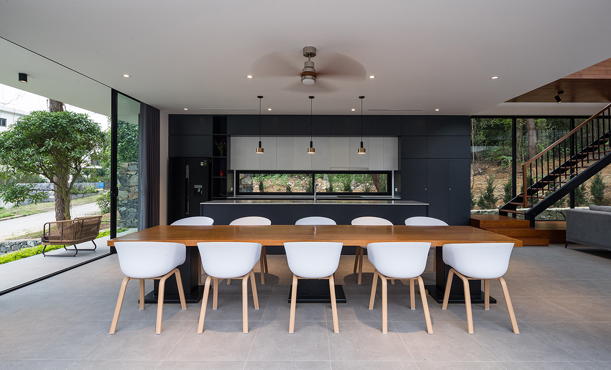 h&igrave;nh ảnh ph&ograve;ng ăn rộng r&atilde;i với b&agrave;n gỗ d&agrave;i, ghế trắng, đ&egrave;n LED &acirc;m trần