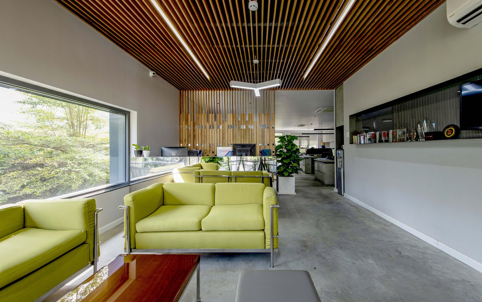 h&igrave;nh ảnh ph&ograve;ng tiếp kh&aacute;ch trong t&ograve;a văn ph&ograve;ng với ghế sofa m&agrave;u xanh l&aacute; c&acirc;y