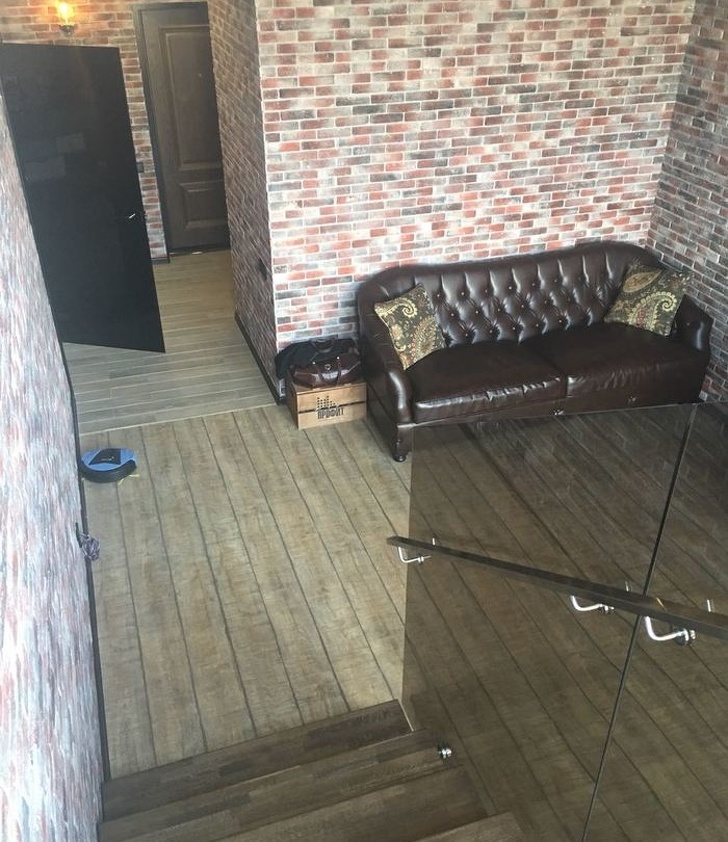 hình ảnh một căn phòng với sofa da đen cổ điển, tường gạch nung, bóng đèn sợi đốt