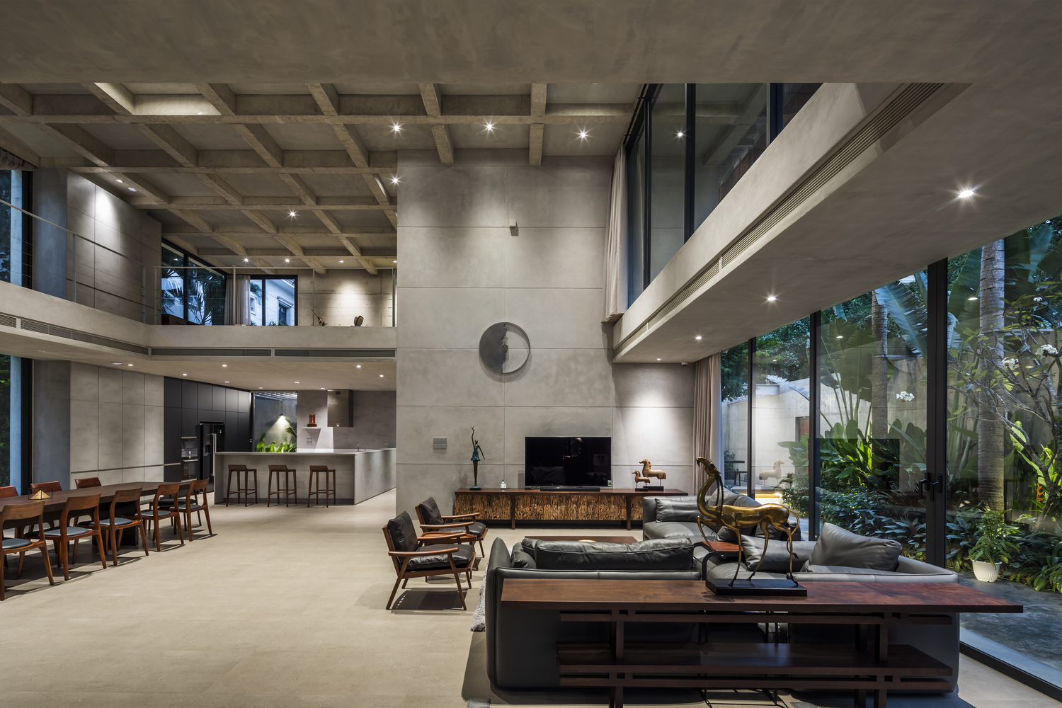 Phòng khách và bếp ăn liền kề hình ảnh phòng khách và bếp ăn liền kề với trần bê tông cao thoáng, gắn đèn LED âm trần