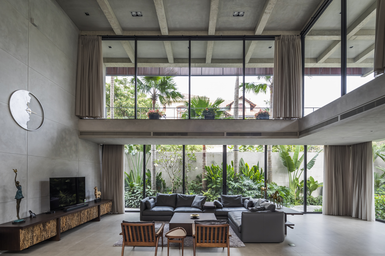 phòng khách rộng rãi, trần cao thoáng hình ảnh phòng khách rộng rãi, trần cao thoáng với bộ ghế sofa màu xám sang trọng, kệ tivi bằng gỗ, đồng hồ lớn treo tường