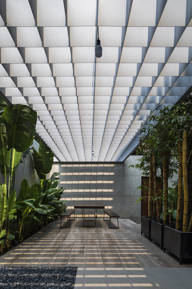 góc thư giãn ngoài trời mang phong cách thiền tịnh hình ảnh góc thư giãn ngoài trời mang phong cách thiền tịnh với bàn ghế gỗ tối giản, sàn xám, khóm tre trúc xanh tốt, rặng chuối đối diện