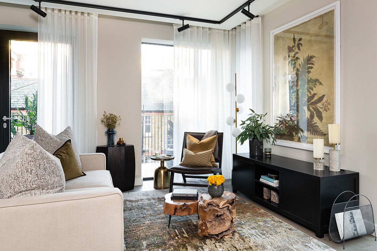 h&igrave;nh ảnh ph&ograve;ng kh&aacute;ch căn hộ t&ocirc;ng m&agrave;u trắng - be chủ đạo với sofa trắng, b&agrave;n tr&agrave; gỗ nguy&ecirc;n c&acirc;y, tủ kệ m&agrave;u đen, c&acirc;y xanh trang tr&iacute;
