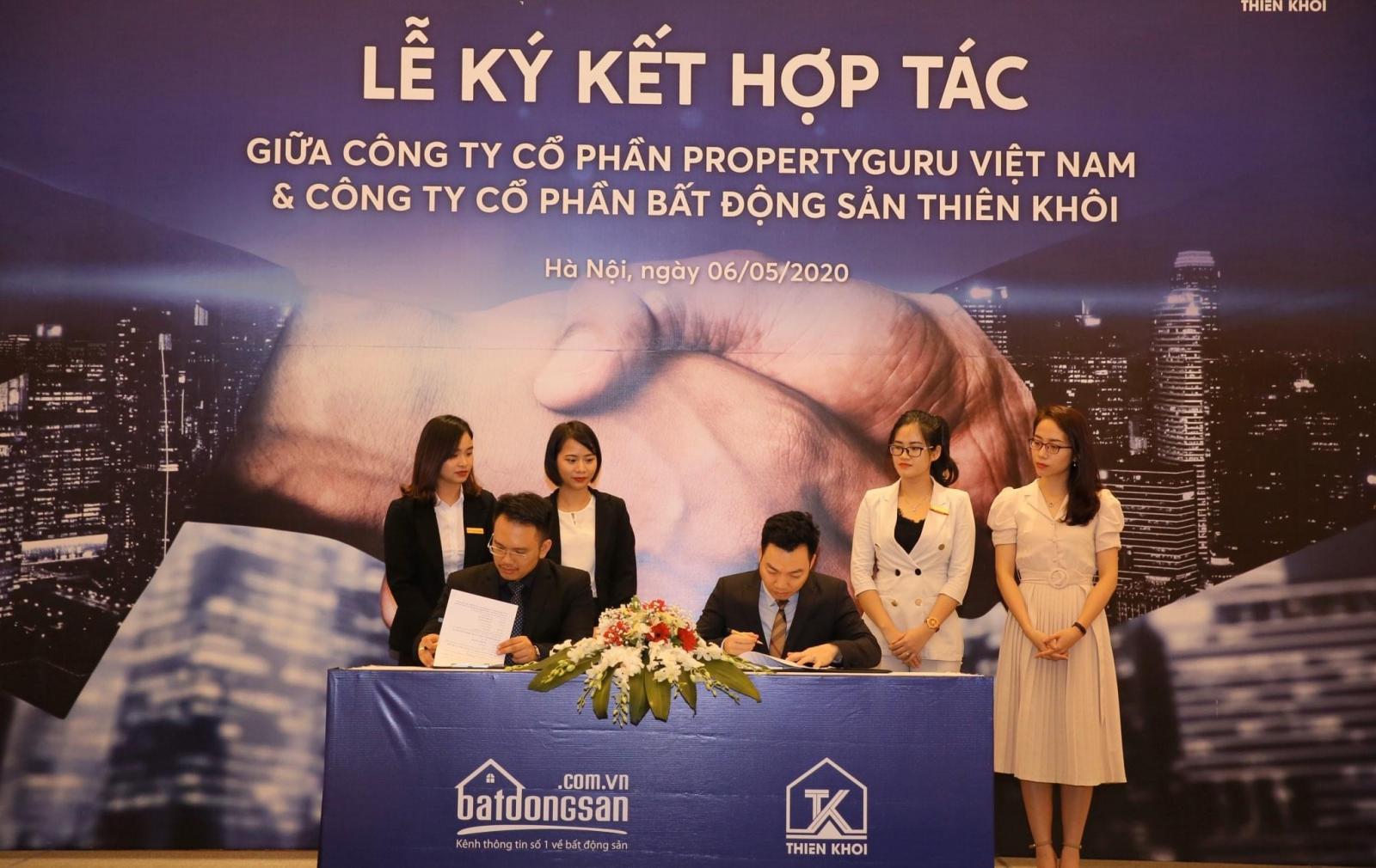 Trong ảnh có 6 người, 2 người ngồi trước cầm bút ký, 4 người đứng phía sau