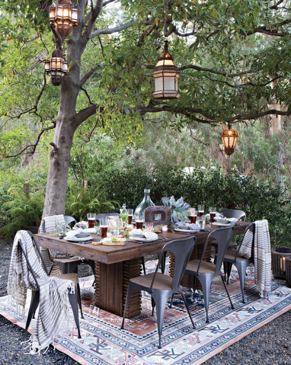 H&igrave;nh ảnh bộ b&agrave;n ăn ngo&agrave;i trời đặt dưới t&aacute;n c&acirc;y xanh m&aacute;t, ghế ngồi phong c&aacute;ch c&ocirc;ng nghiệp m&agrave;u x&aacute;m đen