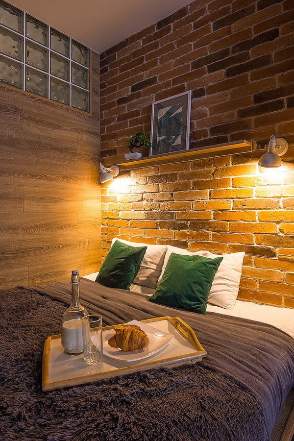 h&igrave;nh ảnh ph&ograve;ng ngủ nhỏ được trang tr&iacute; với tường gạch đầu giường, đ&egrave;n chiếu s&aacute;ng, gối m&agrave;u xanh l&aacute;