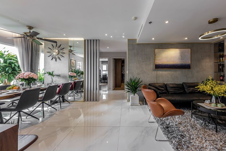 h&igrave;nh ảnh một g&oacute;c ph&ograve;ng kh&aacute;ch sang trọng với sofa da, thảm trải l&ocirc;ng x&aacute;m, cạnh đ&oacute; l&agrave; b&agrave;n ăn