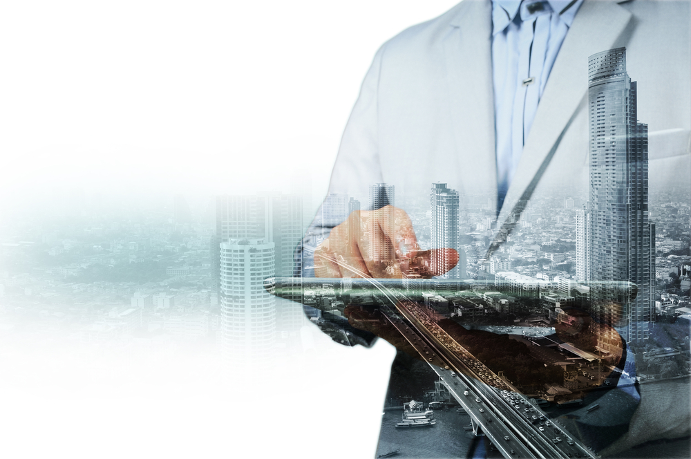 một người cầm ipad tr&ecirc;n tay, m&ocirc; h&igrave;nh bất động sản