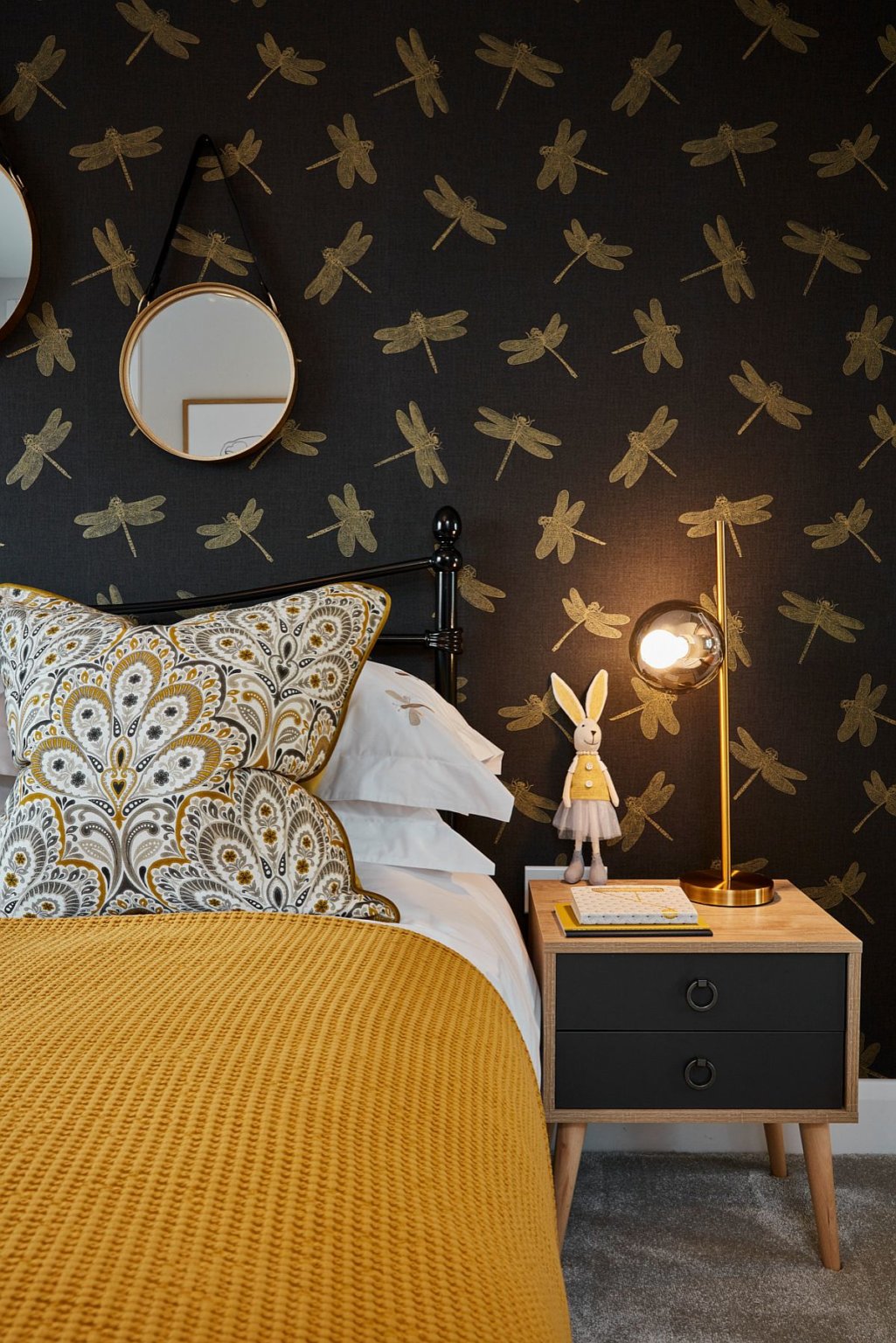 h&igrave;nh ảnh một g&oacute;c ph&ograve;ng ngủ con g&aacute;i với giấy d&aacute;n tường nền đen, họa tiết chuồn chuồn, gối hoa, chăn v&agrave;ng