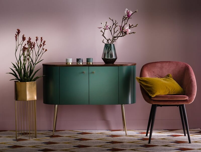 Thiết kế nội thất theo phong cách Art Deco hình ảnh một góc nhà phong cách nội thất Art Deco với tường sơn màu tím nhạt, ghế ngồi màu đỏ đô, tủ màu xanh lá, cây hoa trang trí