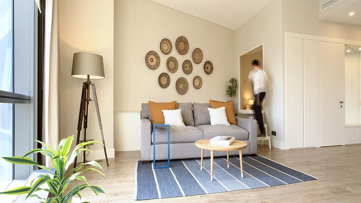 H&igrave;nh ảnh to&agrave;n cảnh ph&ograve;ng kh&aacute;ch căn hộ 45m2, người đ&agrave;n &ocirc;ng đang tr&egrave;o thang