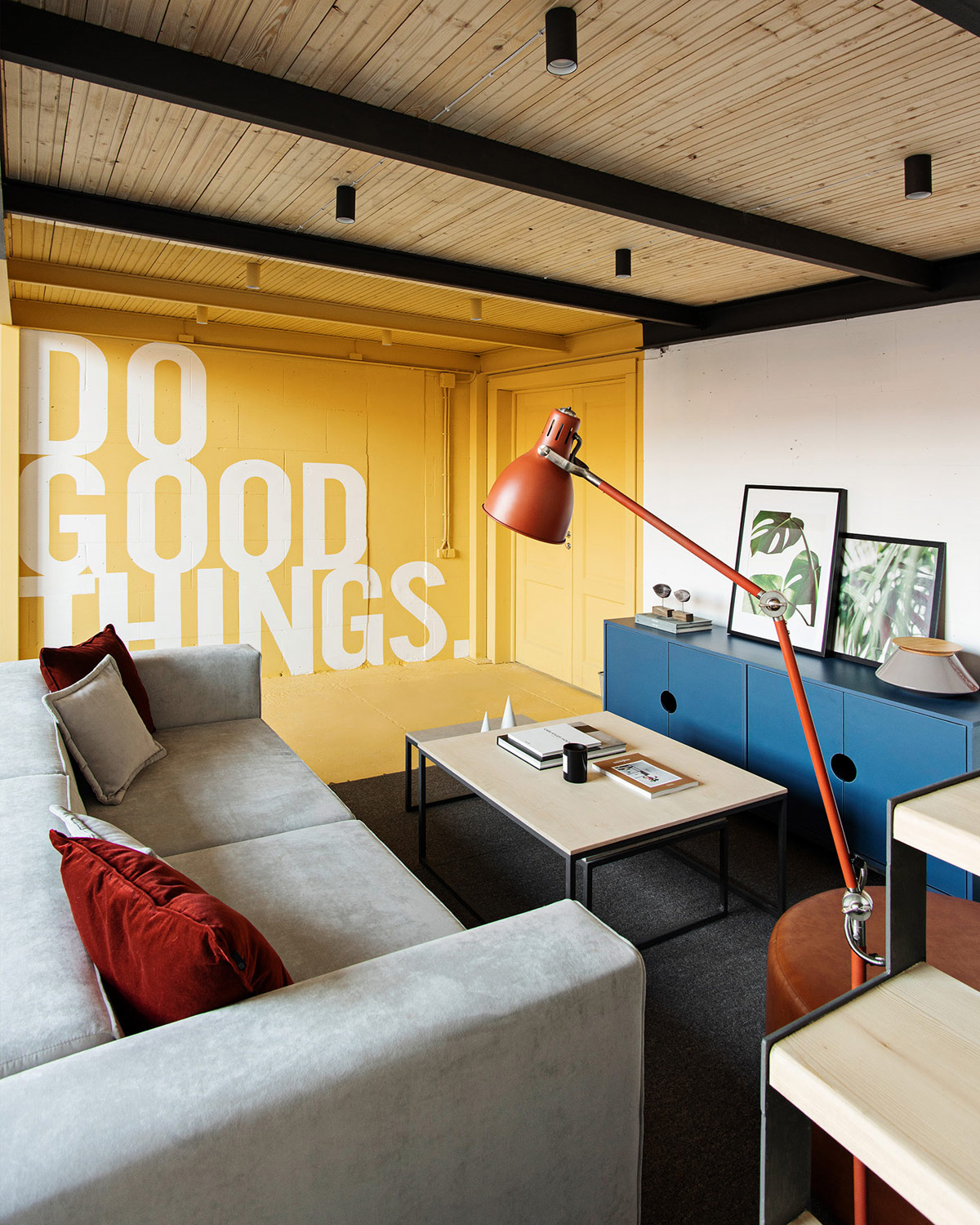 h&igrave;nh ảnh ph&ograve;ng họp nh&oacute;m với sofa ghi x&aacute;m, b&agrave;n tr&agrave; gỗ, tủ lưu trữ m&agrave;u xanh, bức tường v&agrave;ng điểm nhấn