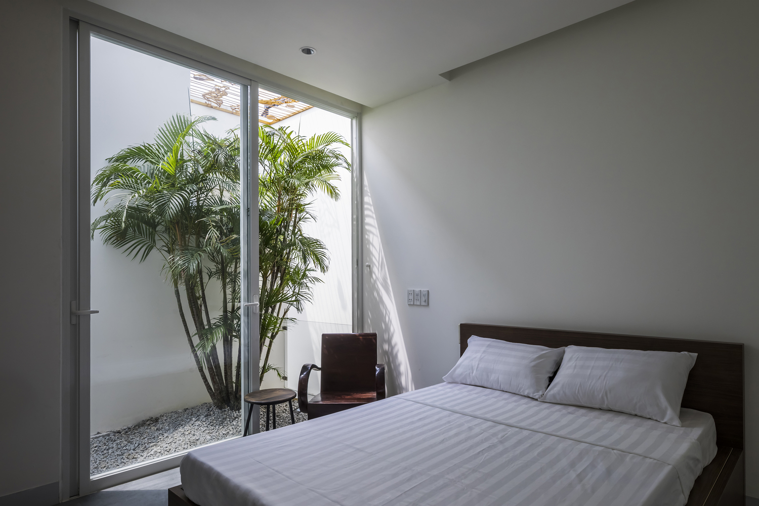 h&igrave;nh ảnh ph&ograve;ng ngủ phong c&aacute;ch tối giản, cạnh đ&oacute; l&agrave; tiểu cảnh kh&ocirc; trồng c&acirc;y xanh 