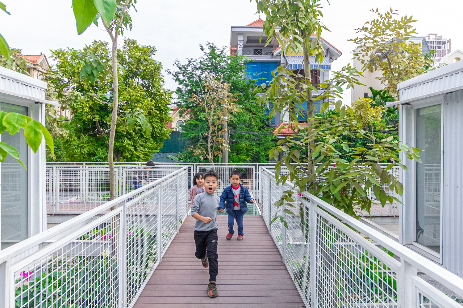 Trẻ chạy nhảy trong khu&ocirc;n vi&ecirc;n trường học gần gũi với thi&ecirc;n nhi&ecirc;n