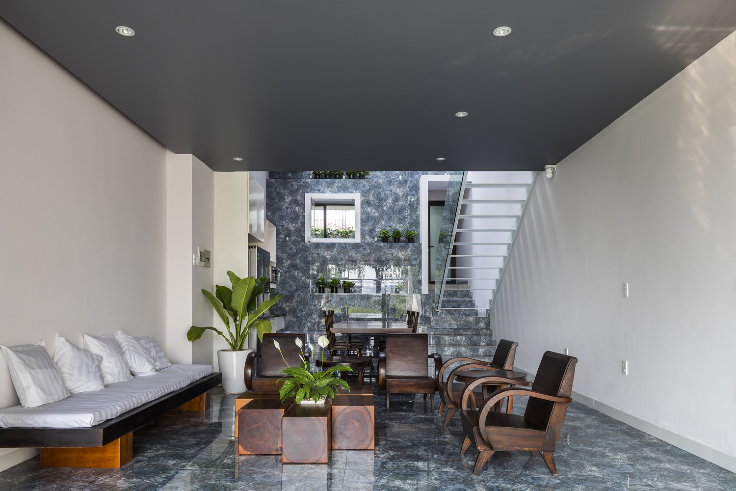 h&igrave;nh ảnh ph&ograve;ng kh&aacute;ch tho&aacute;ng s&aacute;ng với bộ sofa gỗ tự nhi&ecirc;n sang trọng, những chậu cảnh lớn trang tr&iacute;