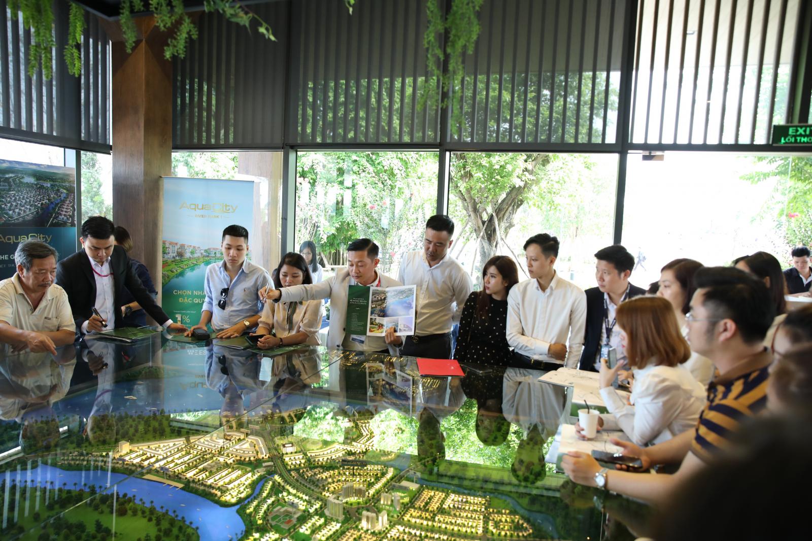 Một nhóm nhà đầu tư xem giới thiệu sa bàn dự án bất động sản.
