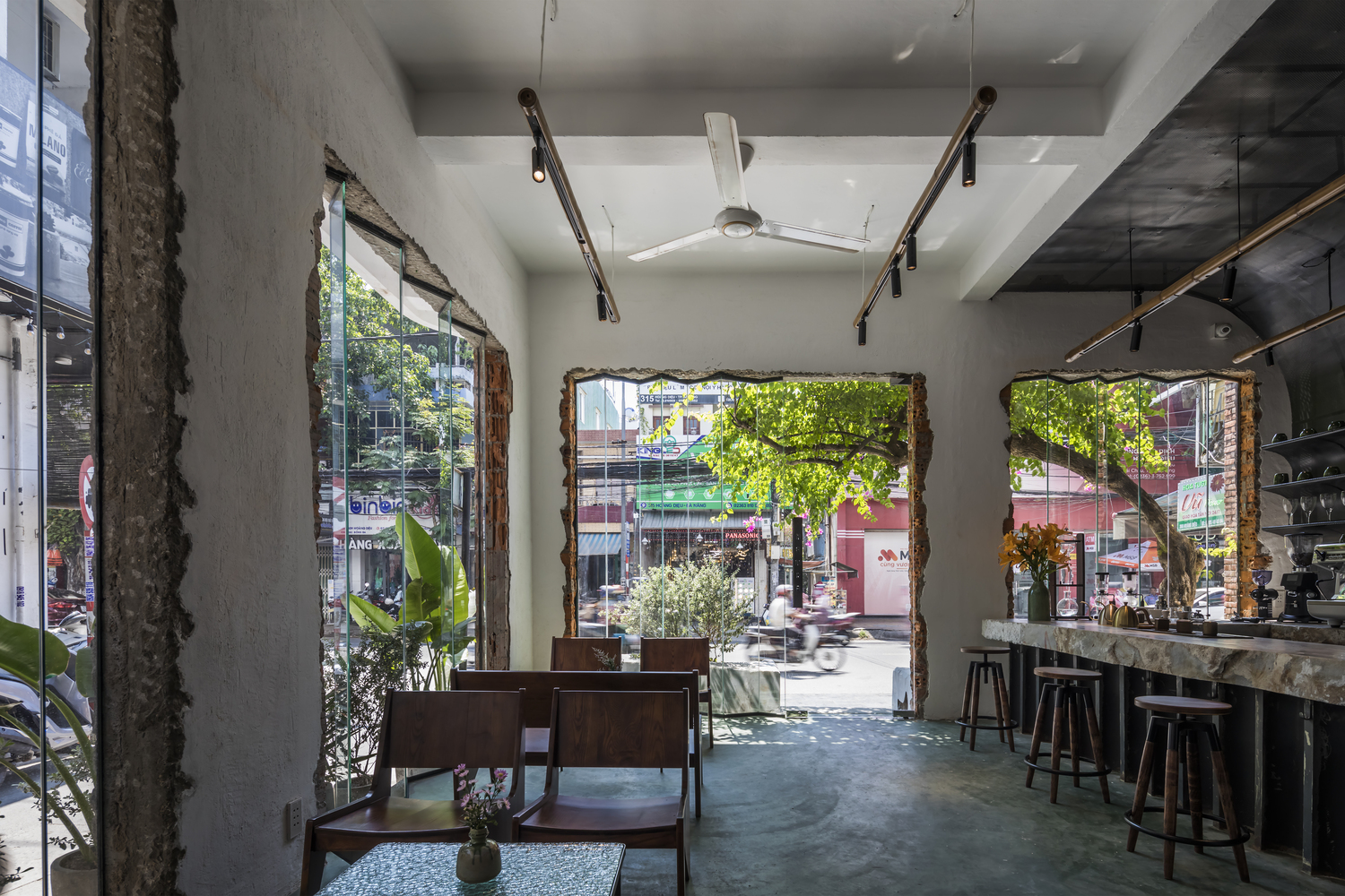h&igrave;nh ảnh kh&ocirc;ng gian b&ecirc;n trong qu&aacute;n c&agrave; ph&ecirc; với b&agrave;n ghế gỗ mộc mạc, c&acirc;y xanh hiện diện khắp mọi kh&ocirc;ng gian 