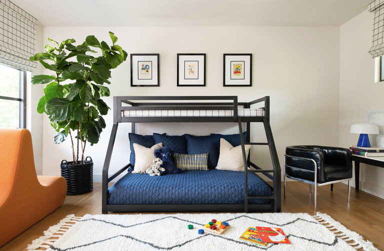hình ảnh toàn cảnh phòng ngủ của trẻ với giường tầng, sofa màu vàng, ghế, tranh treo tường, chậu cảnh lớn ở góc phòng tựa bọc da