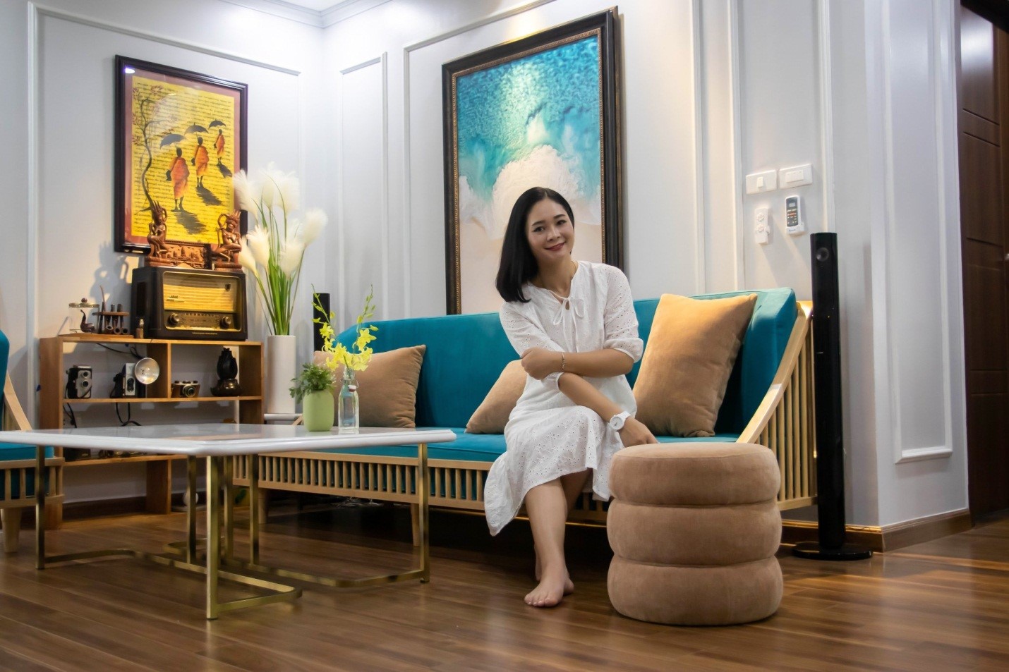 h&igrave;nh ảnh một phụ nữ trẻ tuổi ngồi tr&ecirc;n ghế sofa ph&ograve;ng kh&aacute;ch căn hộ