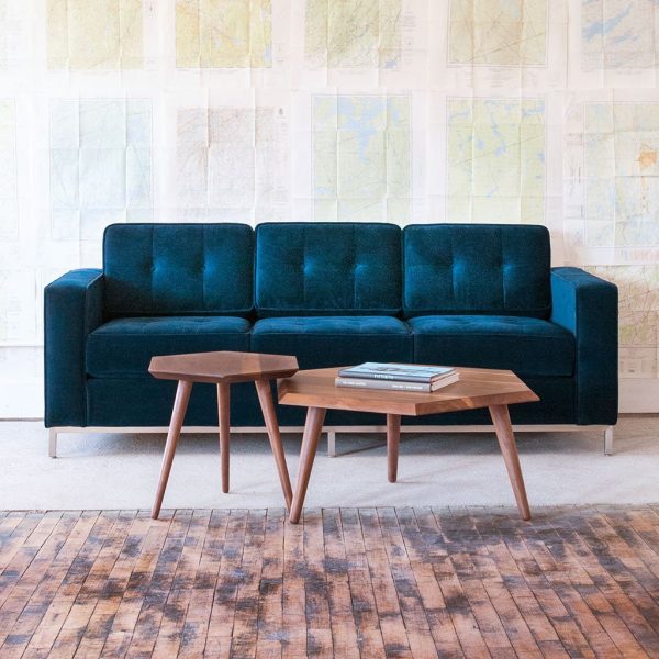 h&igrave;nh ảnh cận cảnh mẫu b&agrave;n c&agrave; ph&ecirc; gỗ h&igrave;nh học bắt mắt, cạnh đ&oacute; l&agrave; sofa m&agrave;u xanh dương