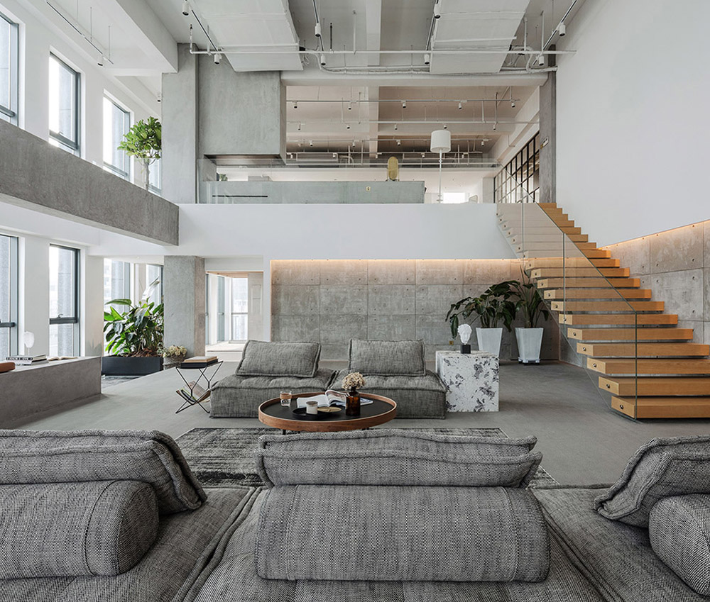 hình ảnh phòng khách biệt thự với sofa ghi xám lớn, bàn trà hình tròn, cây xanh trang trí