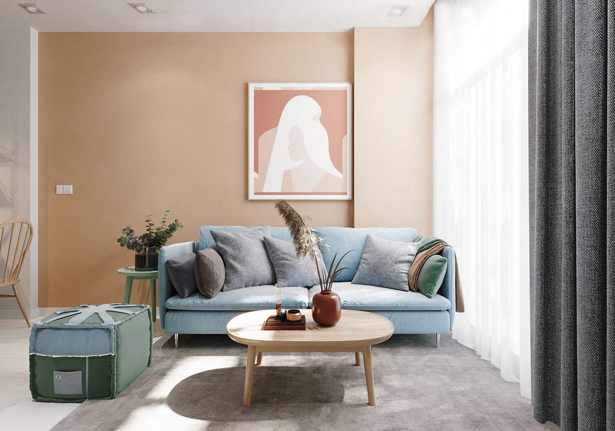 h&igrave;nh ảnh to&agrave;n cảnh ph&ograve;ng kh&aacute;ch với b&agrave;n tr&agrave; gỗ đặt tr&ecirc;n thảm m&agrave;u x&aacute;m, ghế sofa xanh dương, ghế phụ xanh l&aacute;, tranh tường m&agrave;u hồng đất ấm &aacute;p