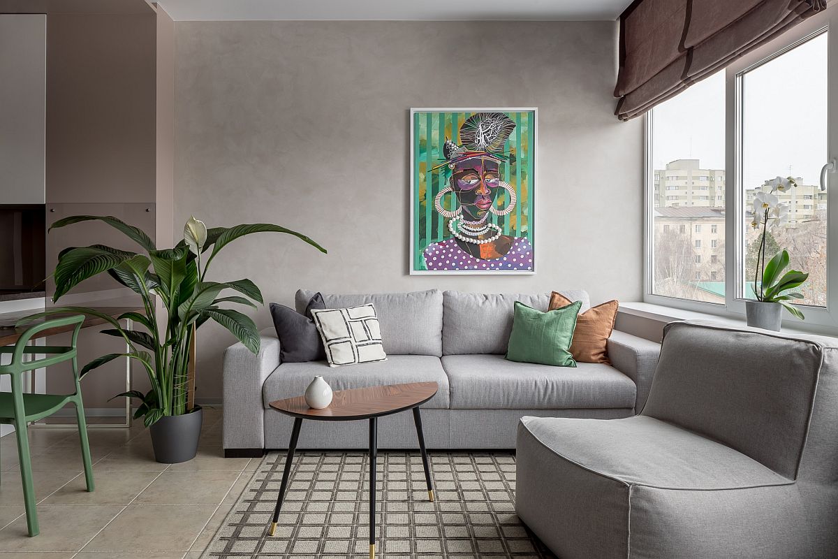 h&igrave;nh ảnh ph&ograve;ng kh&aacute;ch nhỏ với sofa x&aacute;m, tranh tường nghệ thuật, gối tựa xanh l&aacute;, cạnh đ&oacute; l&agrave; bộ b&agrave;n ăn nhỏ xinh